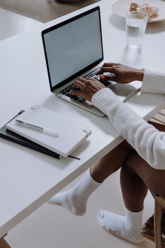 A woman working on a laptop in a modern home office setting, capturing a cozy and productive atmosphere.